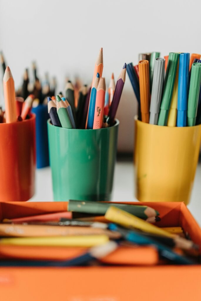 Vibrant pencils and pens arranged in colorful cups, ideal for educational settings.