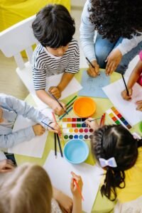 pexels-photo-8612967-8612967 Top view of children painting with watercolors at a preschool art class.